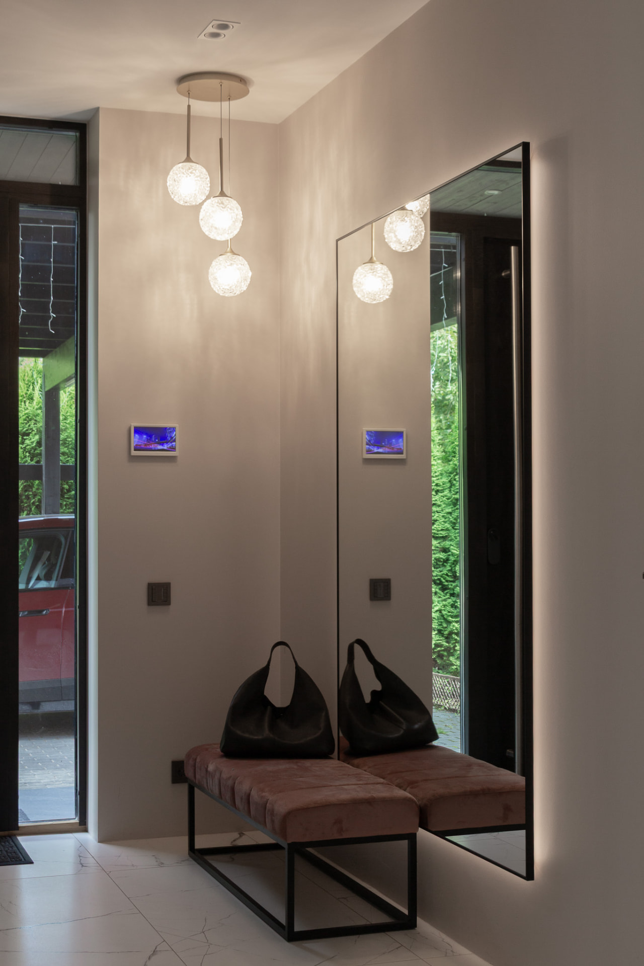 Entrance hall with a full-height backlit mirror and a soft bench