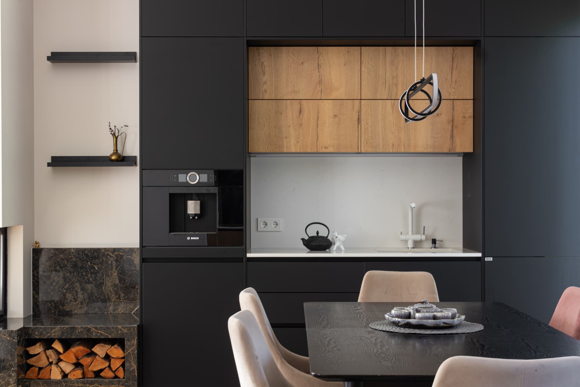 Kitchen and dining area with black cabinetry, oak wall units, island and dining table
