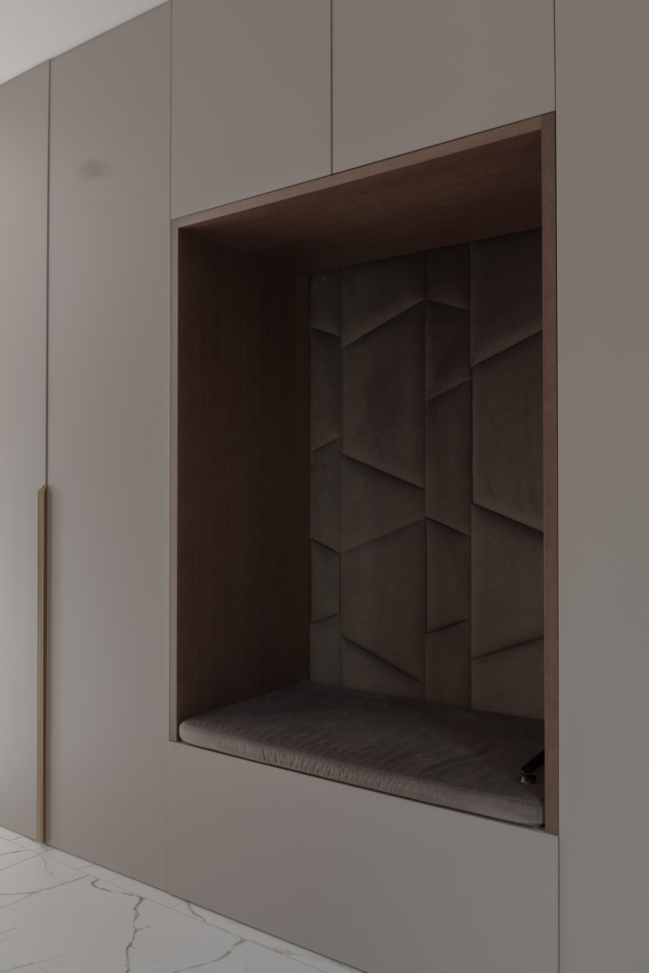 The same upholstered niche seen in daylight, framed in dark oak