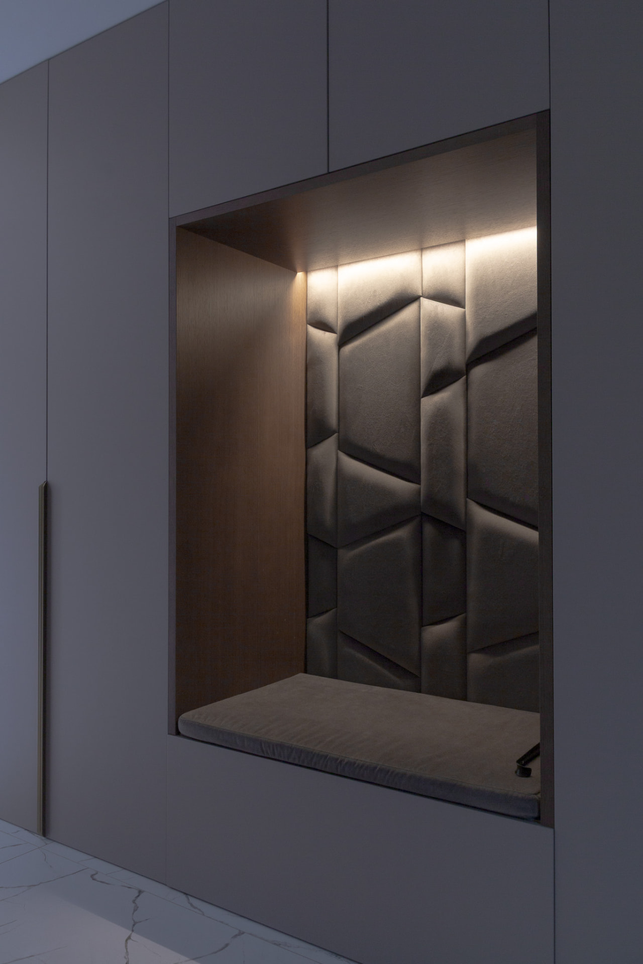 Upholstered niche in the built-in storage, lit from above