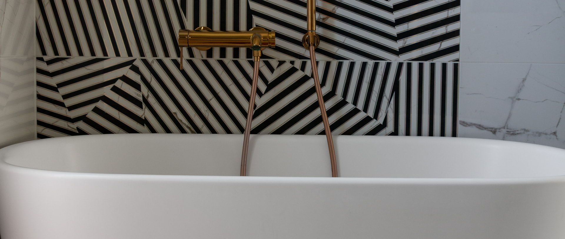 Geometric tiled bathroom with a freestanding bath